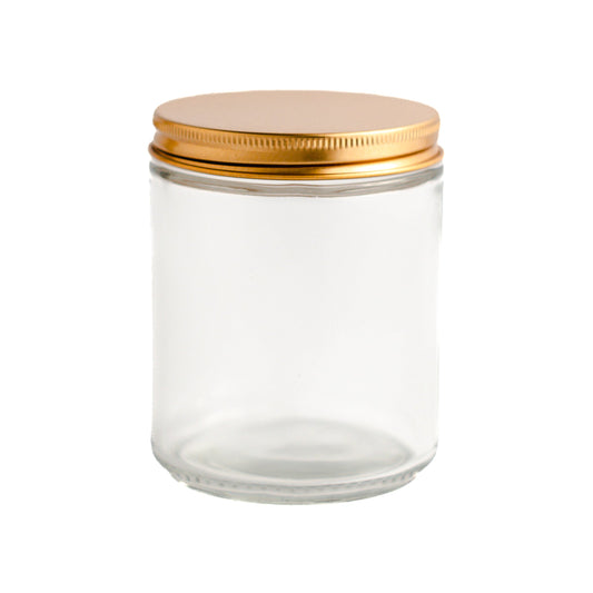 Transparent glass jar with a gold lid on a white background