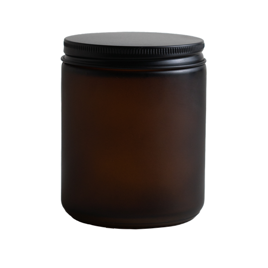 Amber glass jar with a black lid on a white background