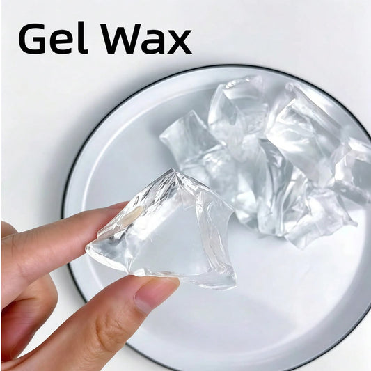 A hand holds a clear, triangular gel wax piece over a white plate with more crumpled clear gel wax pieces on it. The text 'Gel Wax' is printed in black at the top left.