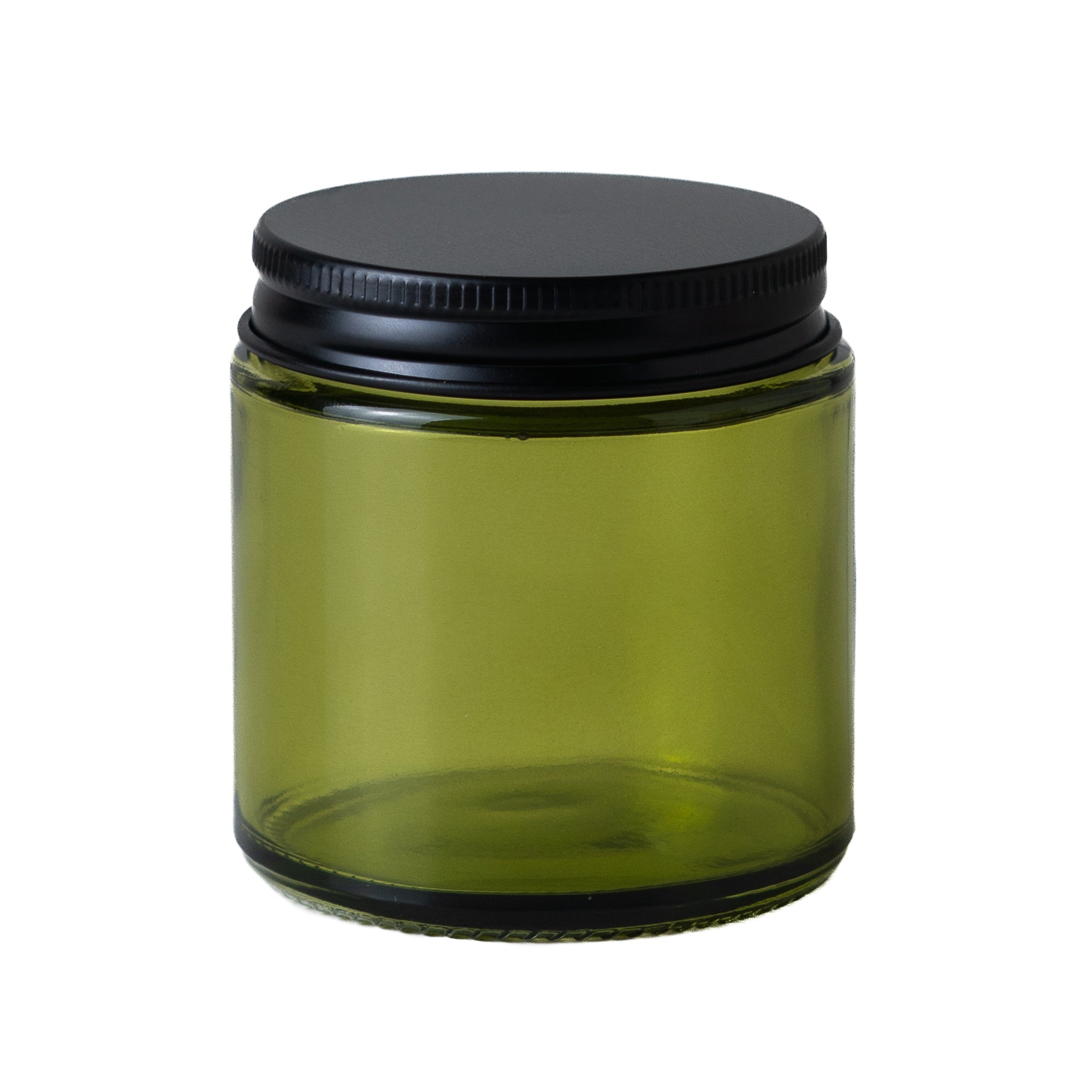 Green glass jar with a black lid on a white background