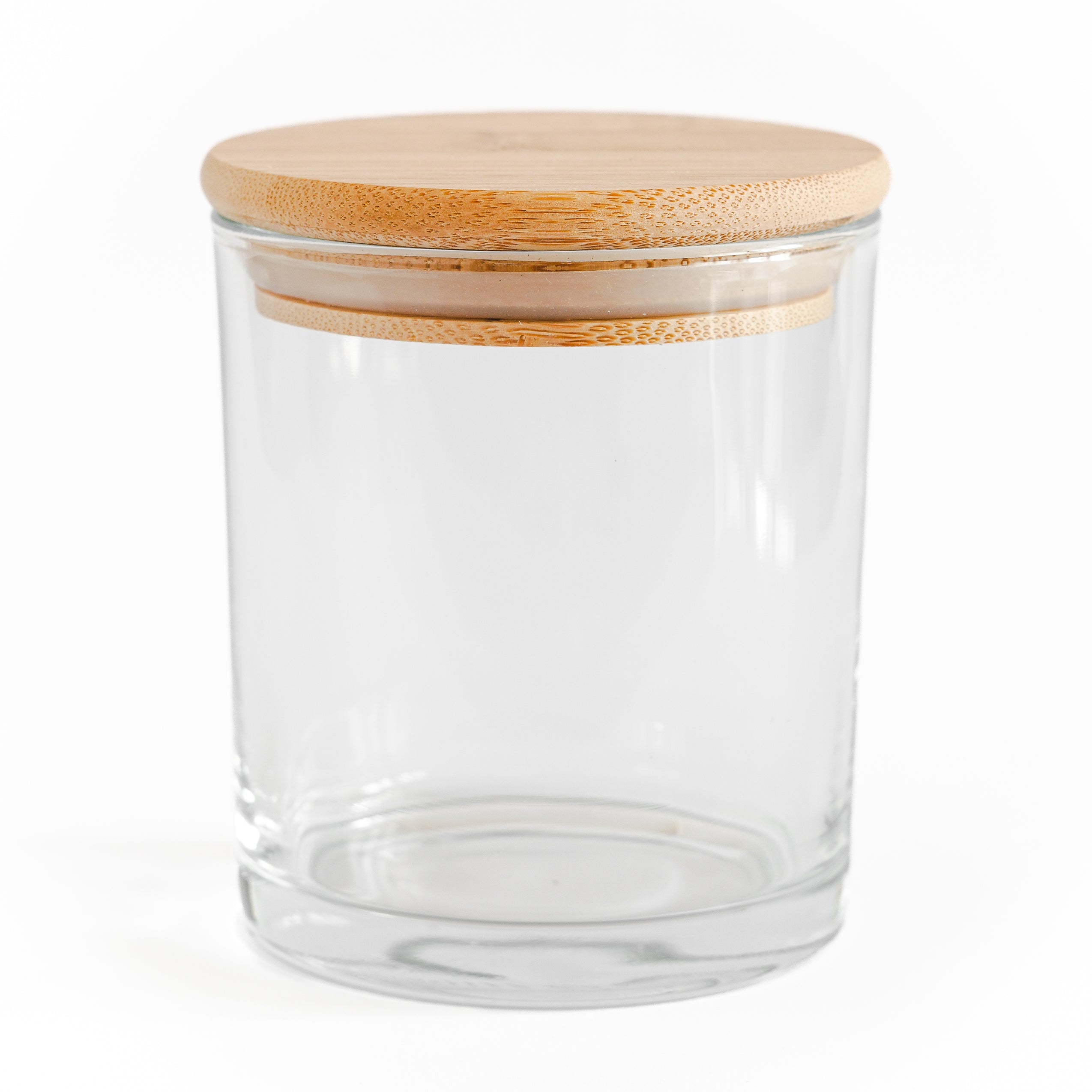 Clear glass jar with a wooden lid on a white background