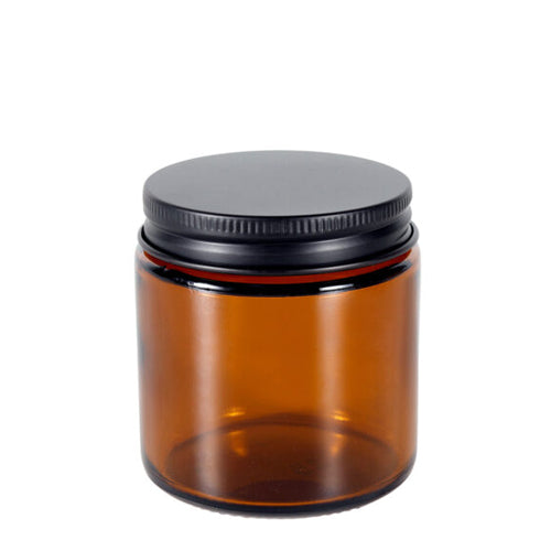 Amber glass jar with a black lid on a white background